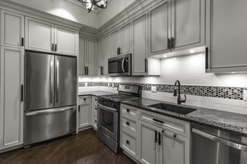 A modern kitchen with stainless steel appliances and white cabinets.