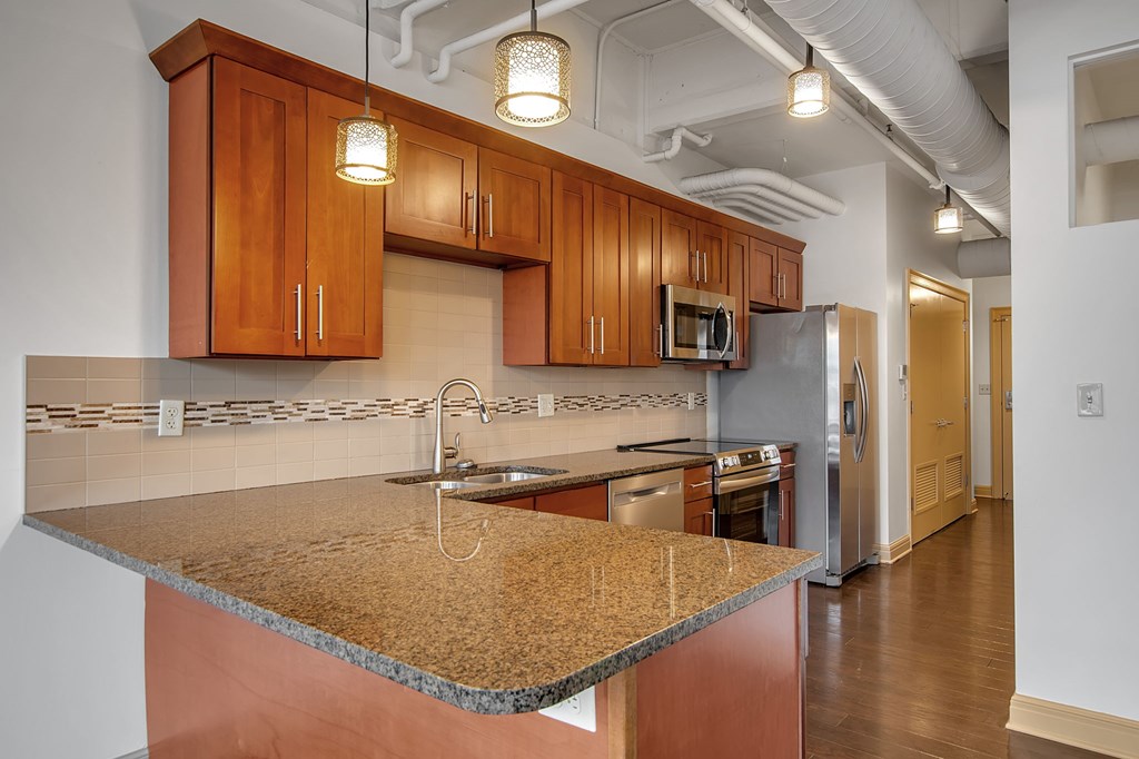 A kitchen with wooden cabinets and a granite countertop.