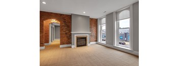 A room with a fireplace and brick walls.