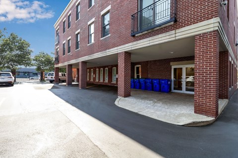 A red brick building with a balcony and a covered walkway.