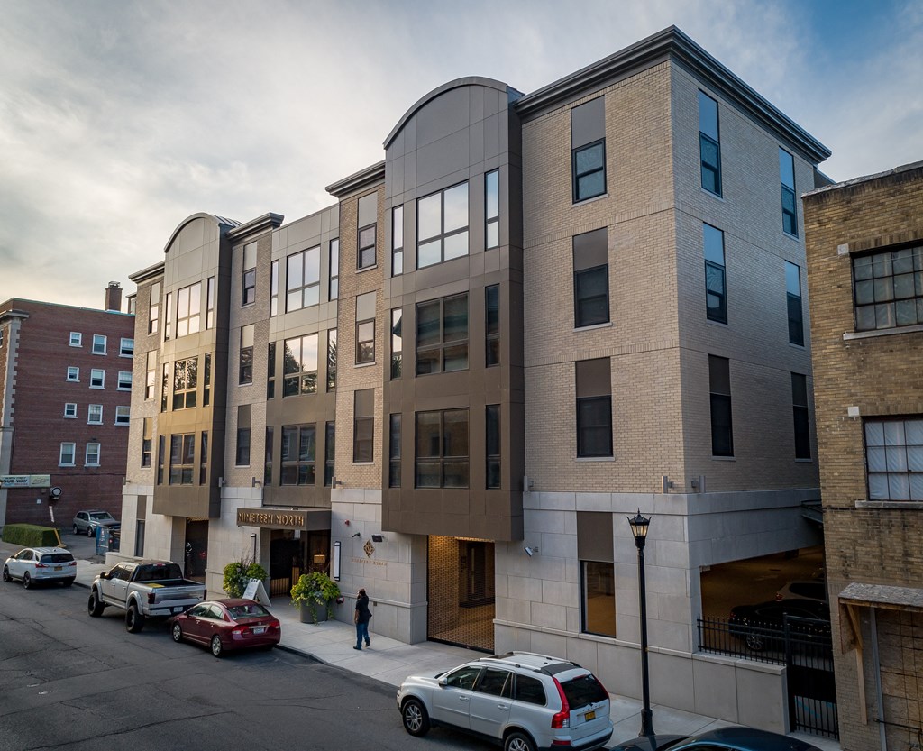 a new apartment building on a city street with cars