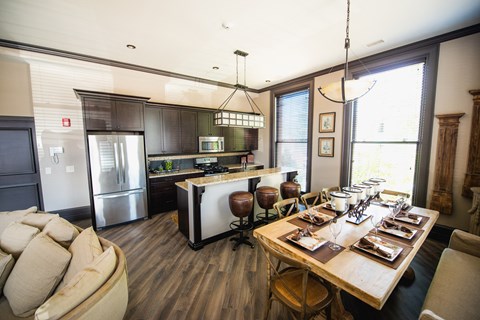 A modern kitchen with a dining table set for six at The Knights @ 506 Delaware Apartments, Buffalo, New York
