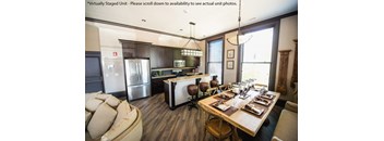A modern kitchen with a dining table set for six at The Knights @ 506 Delaware Apartments, Buffalo, New York