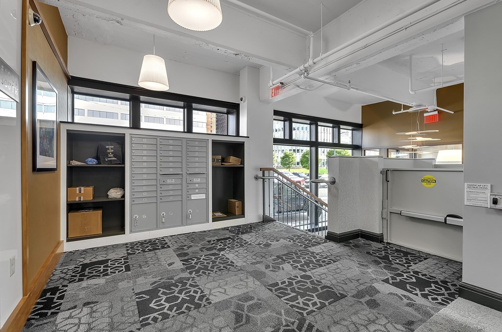 the lobby of a building with a reception desk and a door to a staircase at 100 South Apartments, Buffalo, NY