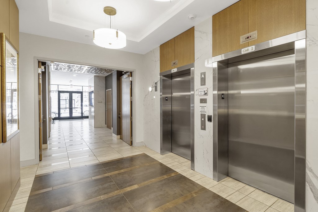 a lobby with elevators and a hallway with doors at Nineteen North, Buffalo, New York