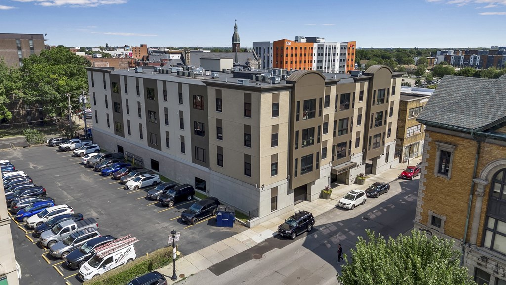 an aerial view of an apartment building with a parking lot and cars parked at Nineteen North, New York, 14202