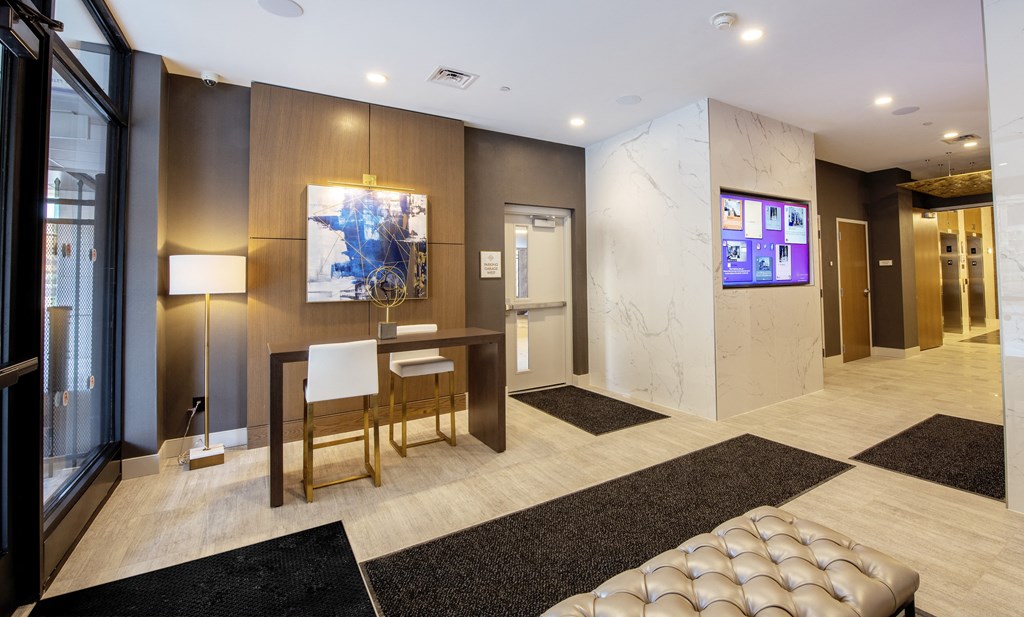 a lobby with a table and chairs and a television at Nineteen North, Buffalo, New York