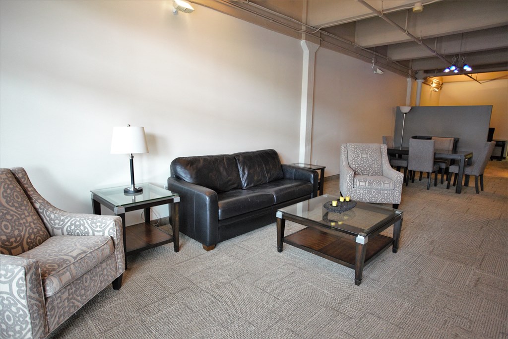 a living room with leather couches and chairs and a table
