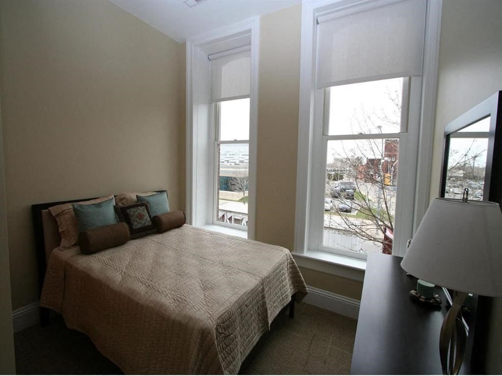 a bedroom with a bed and three windows