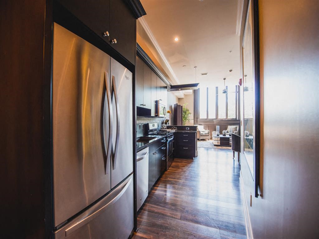a large kitchen with stainless steel appliances and wood floors