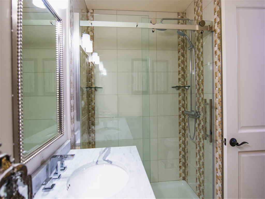 a bathroom with a shower and a sink and a mirror