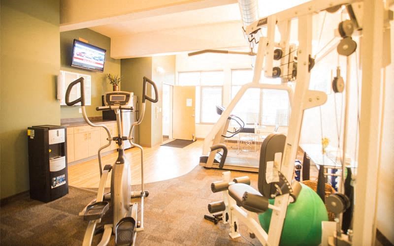 a gym with a simulator and weights on the floor
