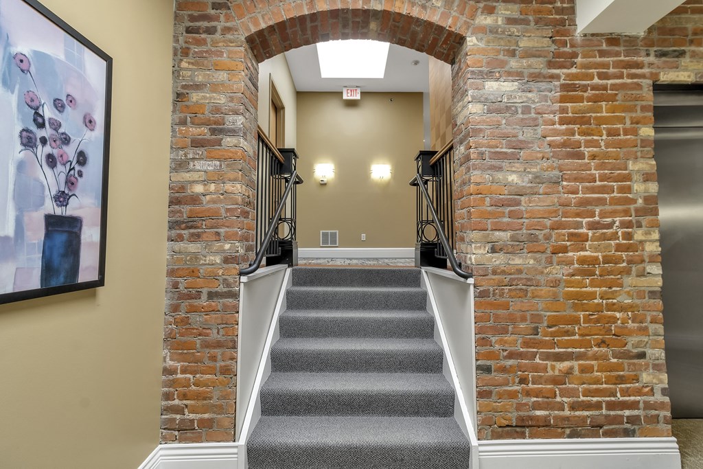 a staircase with brick walls and an arched doorway at The Granite Works Apartments , Buffalo, 14202