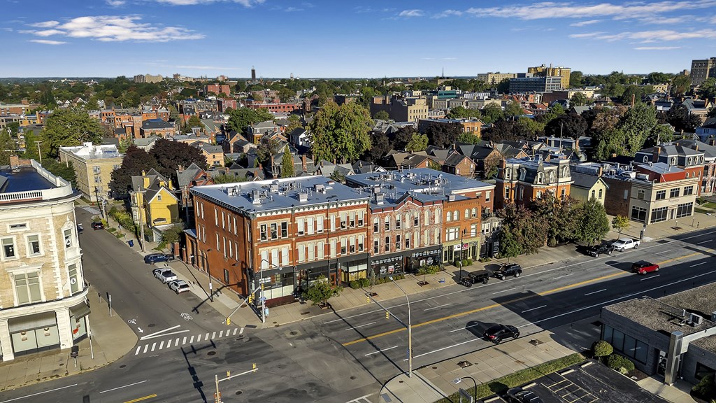 an aerial view of a building with a blue roof on a city street at The Granite Works Apartments , Buffalo