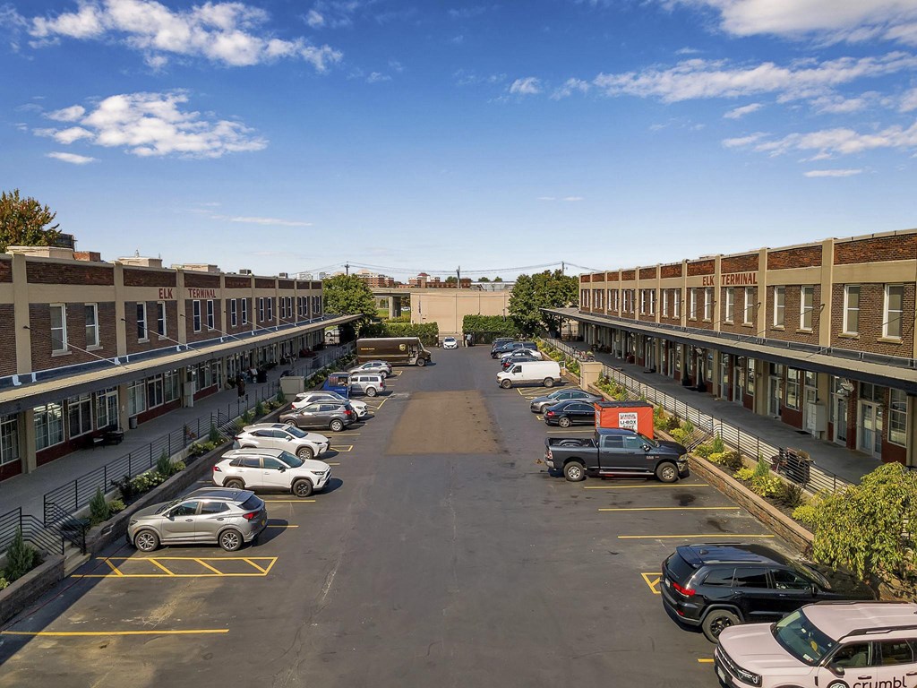 an aerial view of a parking lot with cars and buildings at The Lofts at Elk Terminal, Buffalo, NY, 14204