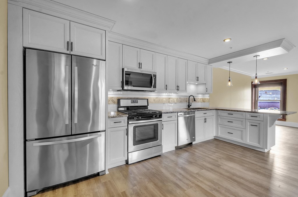 a kitchen with stainless steel appliances and white cabinets at The Knights @ 506 Delaware Apartments, New York
