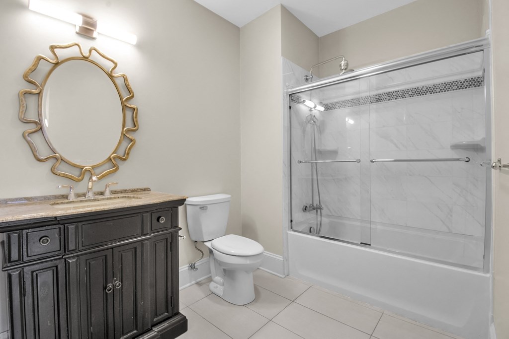 A bathroom with a toilet, sink, and shower at The Knights @ 506 Delaware Apartments, Buffalo, New York