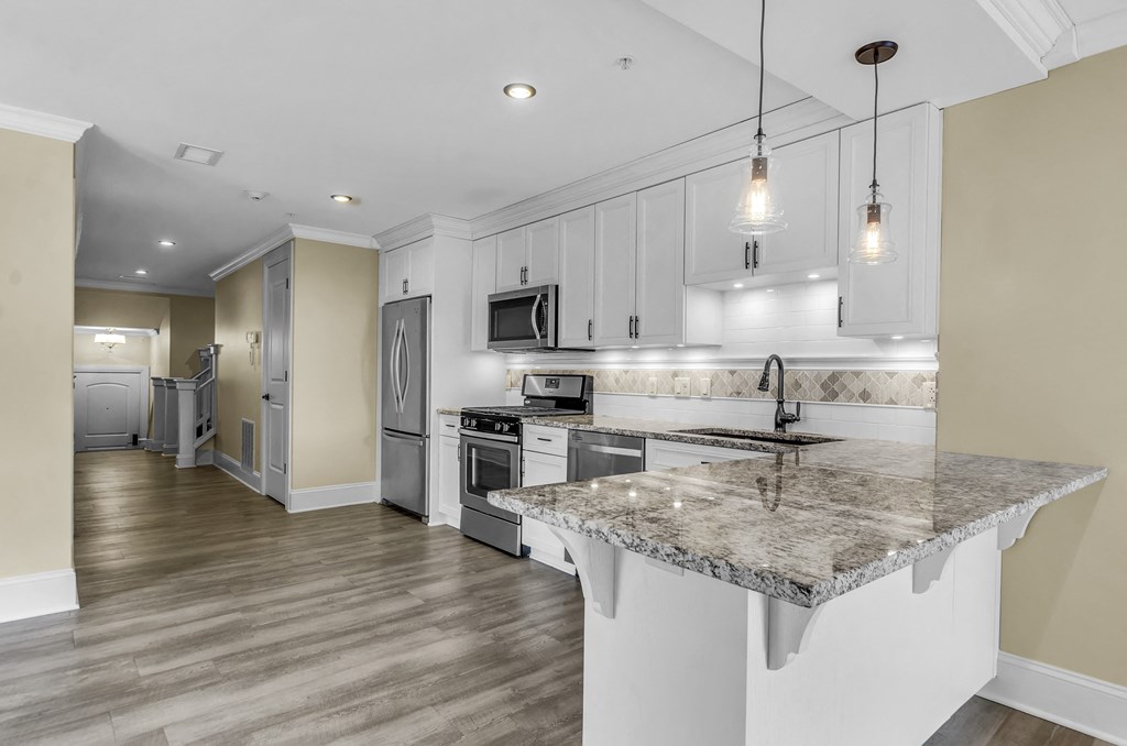 A kitchen with a granite countertop and stainless steel appliances. at The Knights @ 506 Delaware Apartments, Buffalo, NY