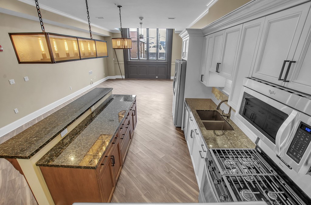 a kitchen with granite counter tops and stainless steel appliances at The Knights @ 506 Delaware Apartments, Buffalo, New York