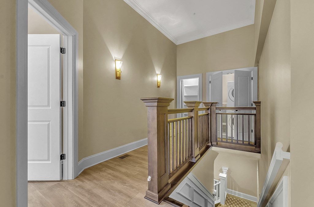 the landing of a staircase in a home with a door to a hallway at The Knights @ 506 Delaware Apartments, Buffalo, NY