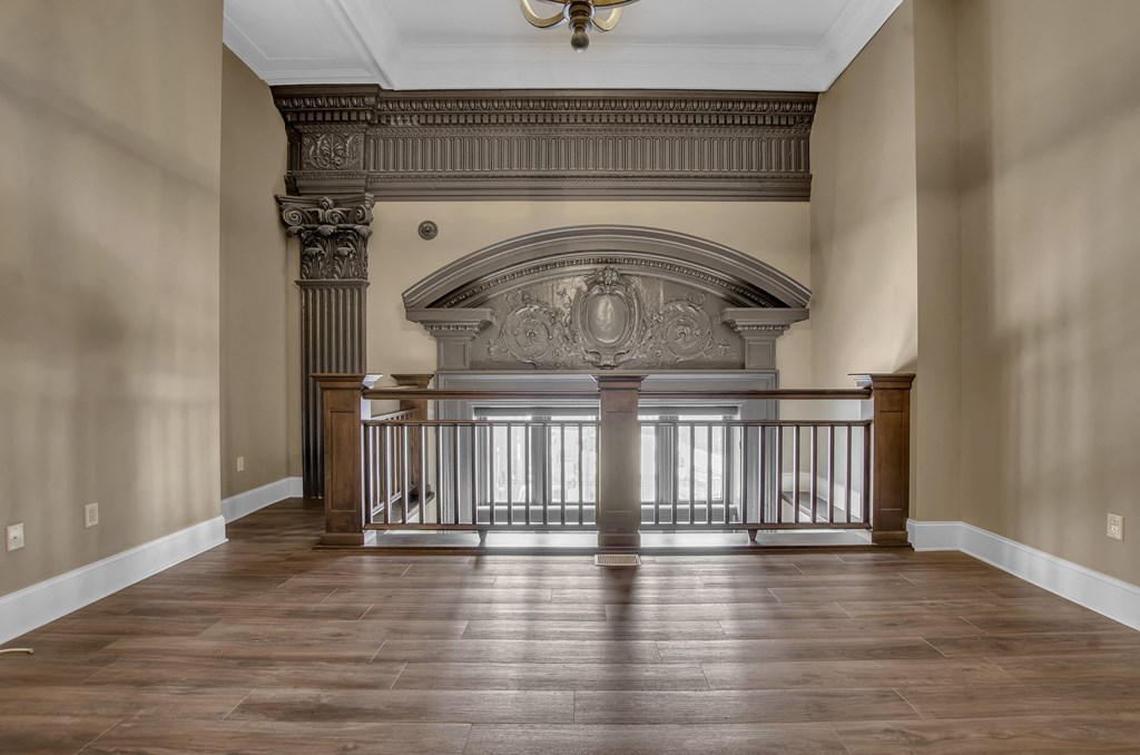 a living room with a fireplace and a wooden floor at The Knights @ 506 Delaware Apartments, Buffalo, 14202