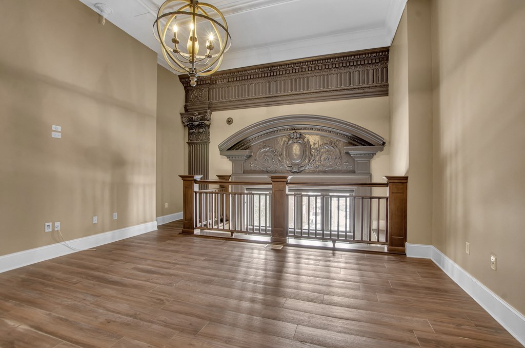 a large living room with a fireplace and a wooden floor at The Knights @ 506 Delaware Apartments, Buffalo, 14202