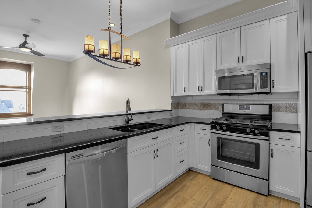 a kitchen with stainless steel appliances and white cabinets at The Knights @ 506 Delaware Apartments, Buffalo, NY 14202