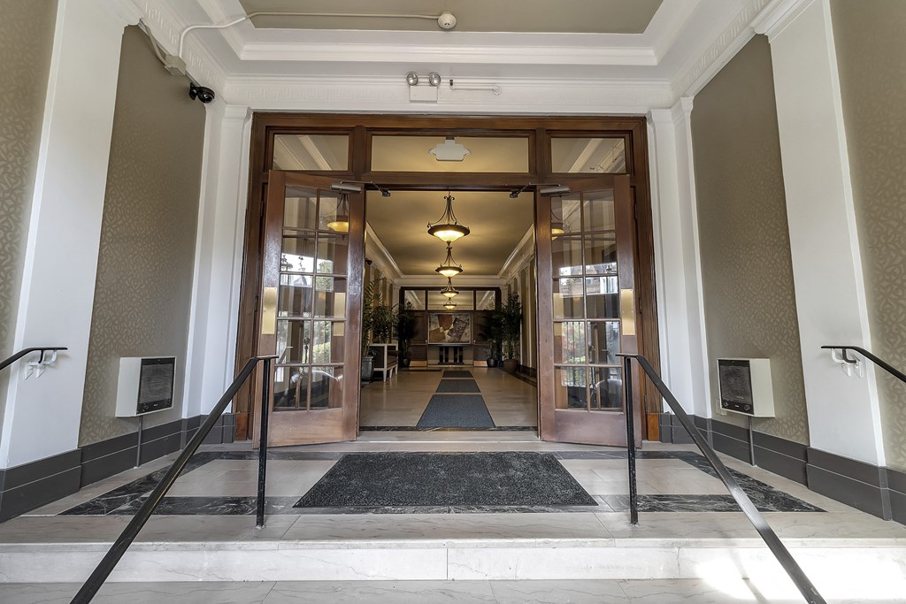 a view of the entrance to the lobby of a building with glass doors a view of the entrance to the lobby of a building with glass doors at The Knights @ 506 Delaware Apartments, Buffalo, NY 14202