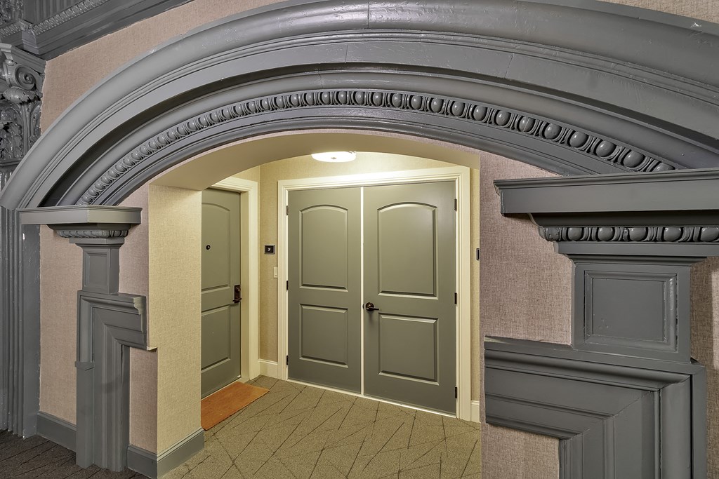 an empty hallway with an archway and two doors at The Knights @ 506 Delaware Apartments, Buffalo, NY 14202
