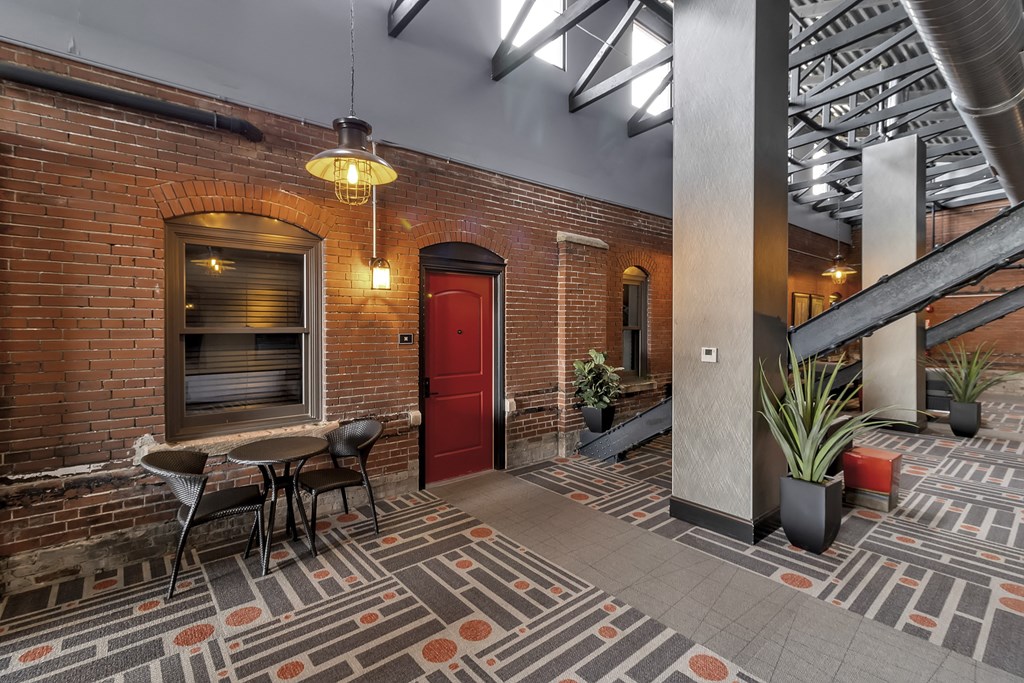 the lobby of a building with a red door and a table and chairs at The Knights @ 506 Delaware Apartments, Buffalo, New York