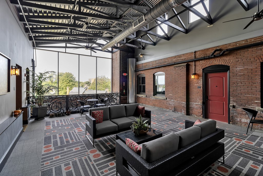 a living room with couches and a red door at The Knights @ 506 Delaware Apartments, Buffalo, NY