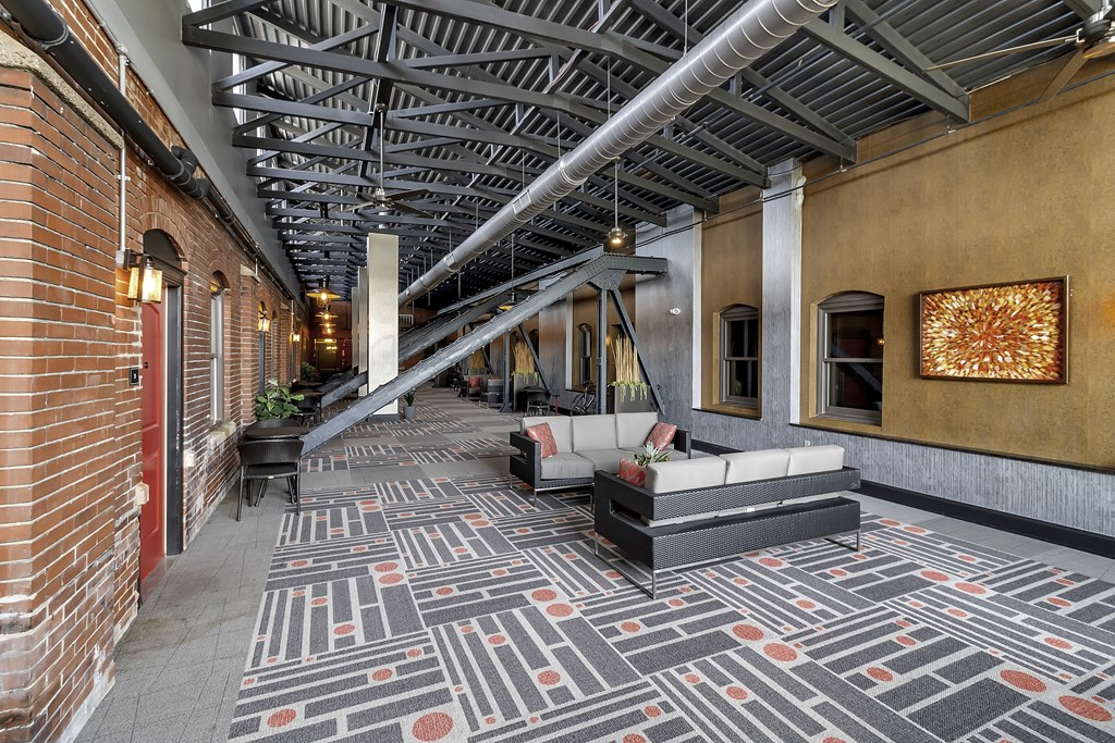 the lobby of a building with couches and a rug at The Knights @ 506 Delaware Apartments, Buffalo, NY 14202