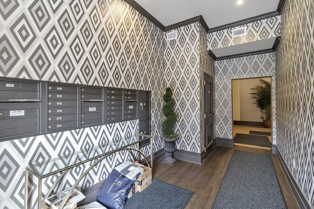 the lobby of a building with mailboxes and a tree in the corner at The Knights @ 506 Delaware Apartments, Buffalo