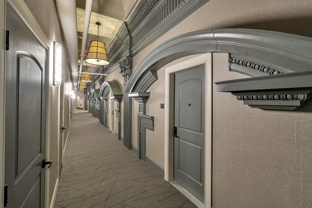 a hallway with white doors and a ceiling with a light fixture at The Knights @ 506 Delaware Apartments, Buffalo
