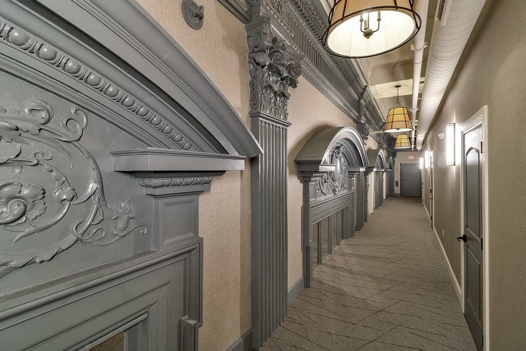 a long hallway with a long row of columns and a ceiling light at The Knights @ 506 Delaware Apartments, Buffalo, NY