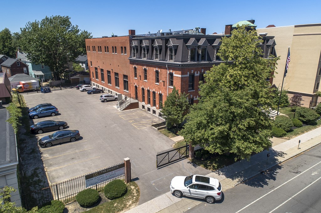 an aerial view of a brick building in a parking lot at The Knights @ 506 Delaware Apartments, New York