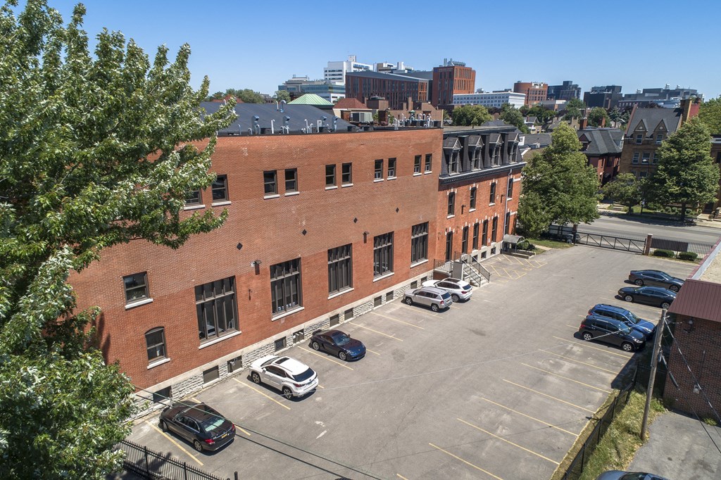 an aerial view of a brick building in a parking lot at The Knights @ 506 Delaware Apartments, Buffalo, New York