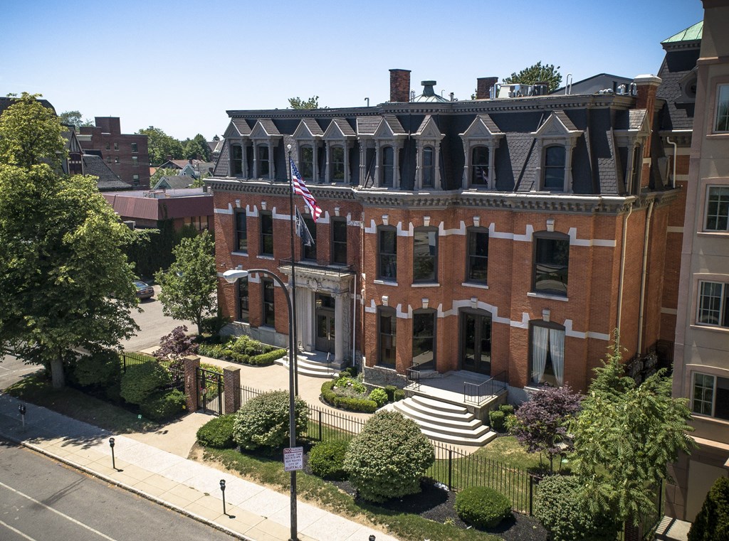 an aerial view of a red brick building with an flag at The Knights @ 506 Delaware Apartments, Buffalo, NY