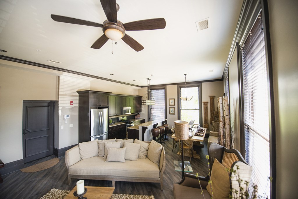 a living room and kitchen with a couch and a ceiling fan at The Knights @ 506 Delaware Apartments, New York