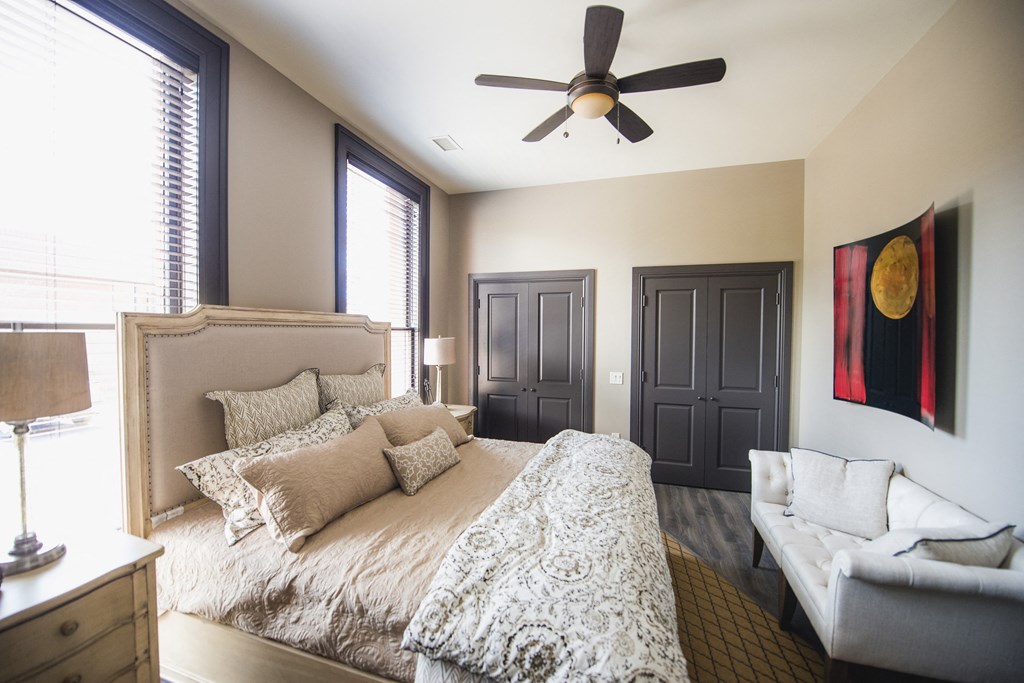 a bedroom with a large bed and a ceiling fan at The Knights @ 506 Delaware Apartments, Buffalo, 14202
