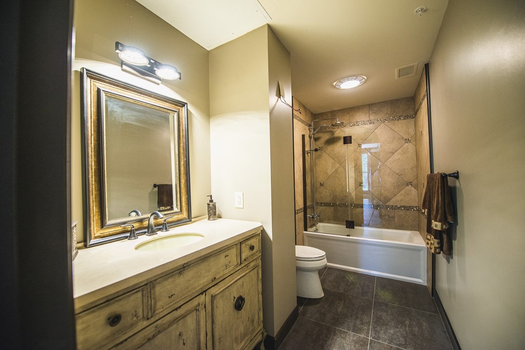 a bathroom with a sink and a shower and a toilet at The Knights @ 506 Delaware Apartments, Buffalo