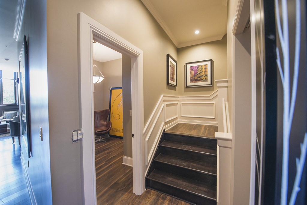 the landing of a staircase in a home with wood floors and white walls at The Knights @ 506 Delaware Apartments, Buffalo, NY 14202