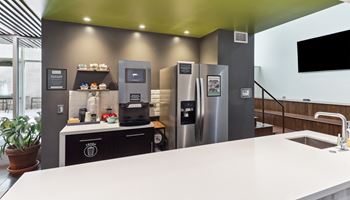 a kitchen with stainless steel refrigerators and a counter with a sink