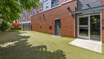 the yard of a brick apartment building with grass and a backdoor Hot Metal Flats apartments, Southside Pittsburgh, PA