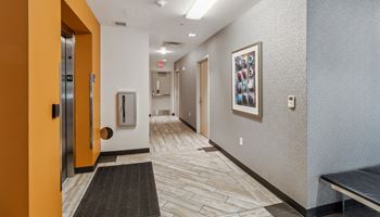 a hallway with doors and a painting on the wall and a door to a room Hot Metal Flats apartments, Southside Pittsburgh, PA