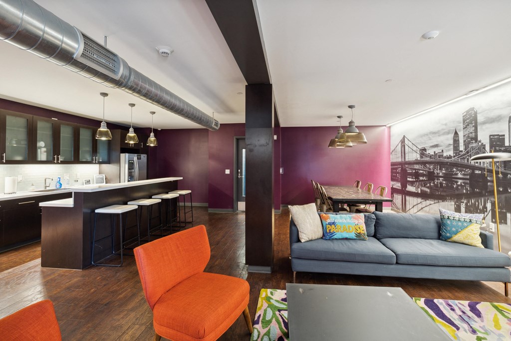 A living room with a couch, chair, and a kitchen area. at Walnut on Highland, Pittsburgh, PA