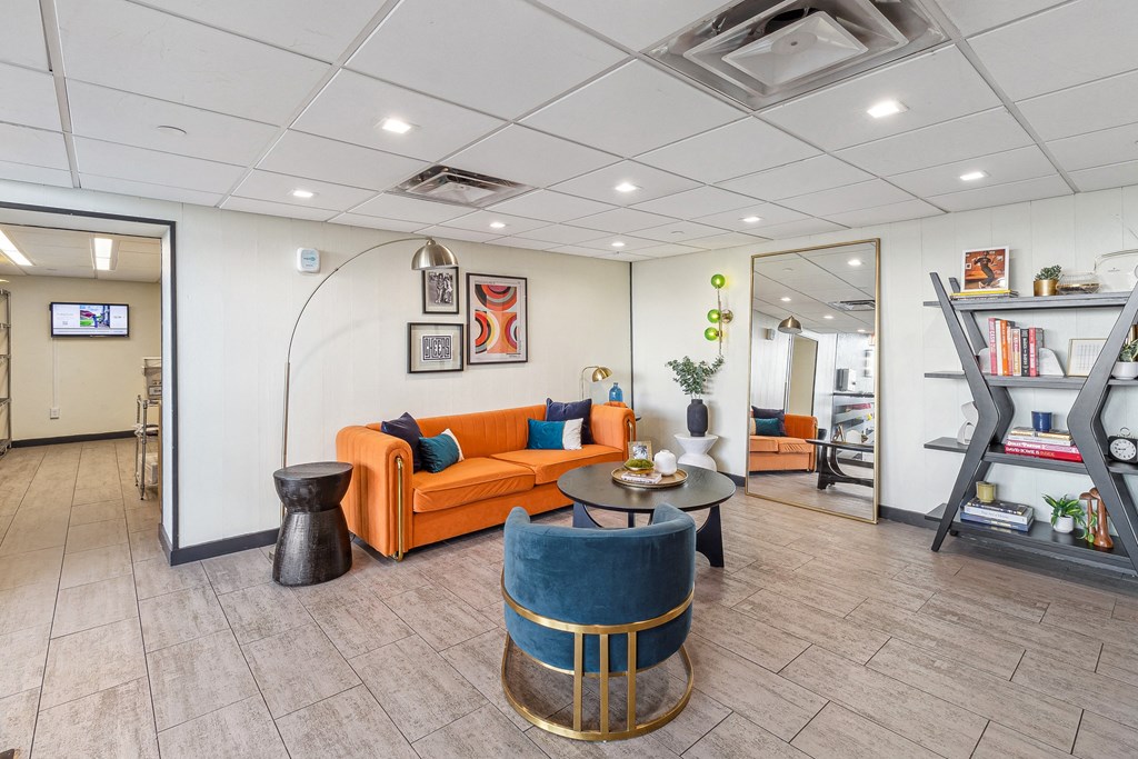 A living room with a blue chair and orange couch at Walnut Towers at Frick Park, Pennsylvania