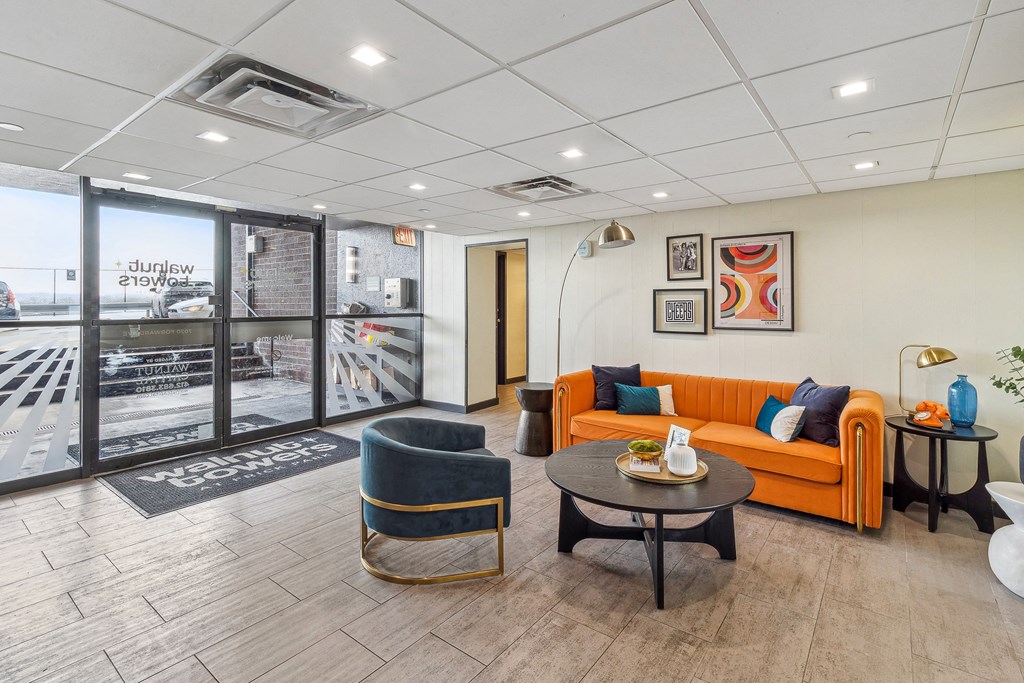 A living room with a sofa, armchair, and coffee tables at Walnut Towers at Frick Park, Pittsburgh