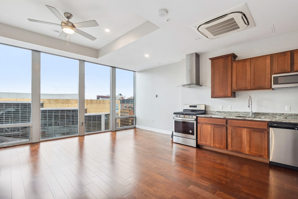A kitchen with wooden floors and a ceiling fan. at The Washington at Chatham, Pennsylvania, 15219