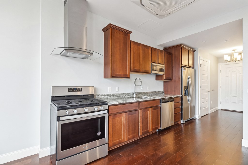 A kitchen with wooden cabinets and stainless steel appliances. at The Washington at Chatham, Pennsylvania, 15219